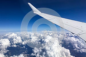 White airplane wing over cloudy sky and view of horizon. Perfect air transportation and travel concept banner