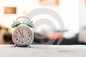 White alarm clock on the bed, morning, copyspace