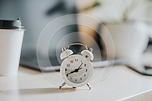 White alarm clock on the desktop in the office