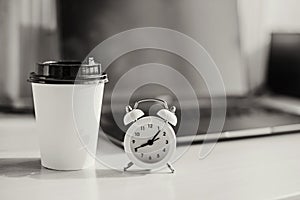 White alarm clock on the desktop in the office