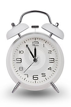 White alarm clock with hands at 5 minutes till 12 photo