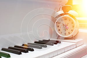 White alarm clock on piano keys
