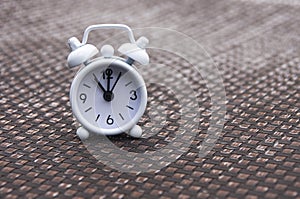 White alarm clock on pool chair. The clock set at 11 o'clock. photo