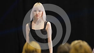 White albino hair girl moving on runway catwalk podium. Female model defile.