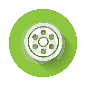 White Alloy wheel for a car icon isolated with long shadow. Green circle button. Vector Illustration
