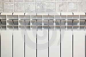 White aluminium hot water heating radiator. Heating convector in the bathroom.