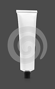 White aluminum toothpaste tube isolated on gray background