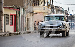 White american vintage car drives in the province Villa Clara in Cuba on the street