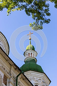 White ancient christian church with golden cross on top against clear blue sky. Religion and faith concept. Church exterior.