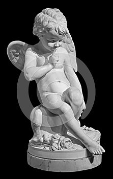 White angel figurine isolated on black background. Cupid sculpture. Stone statue of young cherub