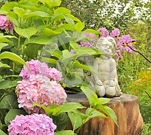 White Angel Statue on Tree Stump in the Garden