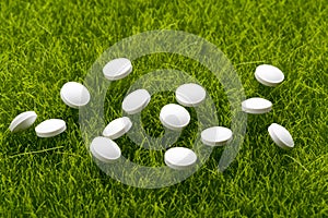 White antibiotic pills scattered on the grass