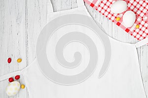 White apron template on wooden background with Easter eggs, copy space. Kitchen, cooking clothing mockup photo