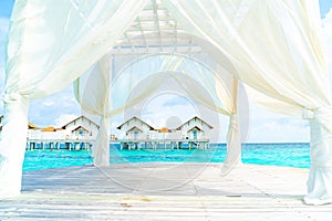 white arch with tropical Maldives resort and sea