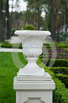 White architectural vase on a pedestal in the park