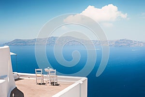 White architecture in Santorini island, Greece. Two chairs on the terrace with sea view