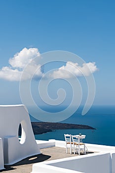 White architecture in Santorini island, Greece. Two chairs on the terrace with sea view