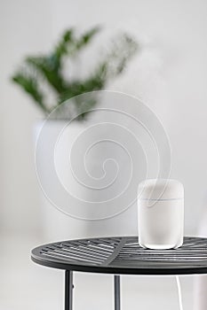 White aroma diffuser on black table in room