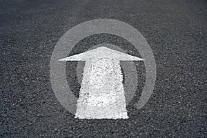 White arrow sign on asphalt road, Traffic symbol on street, Surface rough Texture Background.