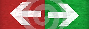 White arrows pointing directions right and left manually painted on green and red wooden signboard background photo