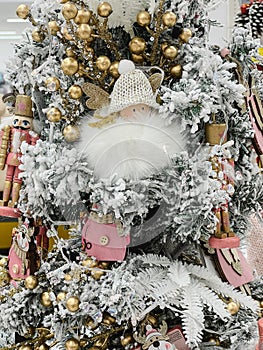 White artificial Christmas tree decorated with angel figurines, tin soldiers and balls