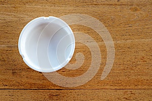 white ashtray on brown wood background