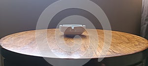 a white ashtray is on the table  brown