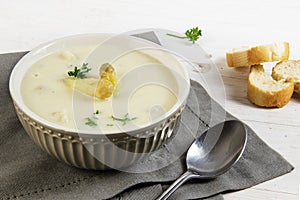 White asparagus cream soup with with parsley garnish in a bowl a