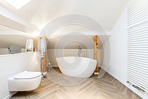 White attic bathroom with bathtub