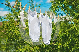 White baby clothes dry on a rope. Selective focus