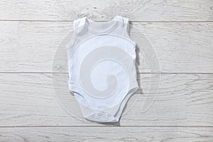 White baby onesie isolated over light wood background. Good for insert your design