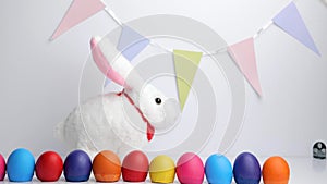 White baby rabbit toy with easter colorful eggs