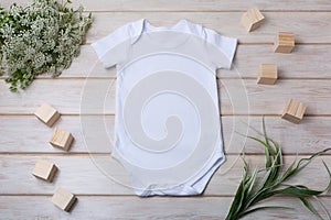 White baby short sleeve bodysuit mockup with green grass and white flowers