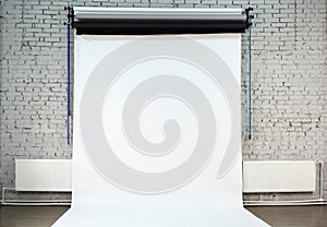 White background on brick wall inside studio