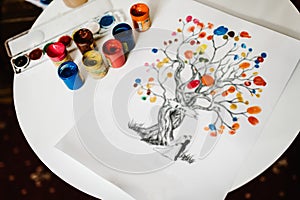 On a white background, a family tree is painted. Fingerprints with colored paints. generation of the whole family. close up
