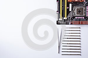 On a white background laid out the motherboard and other computer components and tools