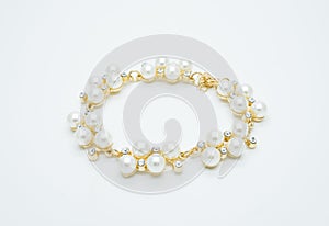 On a white background lies a pearl necklace on the neck and bracelet
