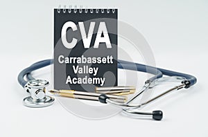 On a white background lies a stethoscope, a pen and a black notebook with the inscription - CVA