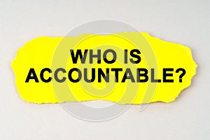 On a white background lies yellow paper with the inscription - WHO IS ACCOUNTABLE