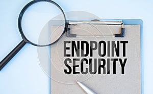 On a white background magnifier, a pen and a sheet of paper with the text endpoint security . Business