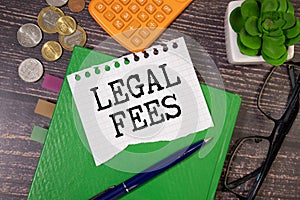 On a white background magnifier, a pen and a sheet of paper with the text LEGAL FEES . Business