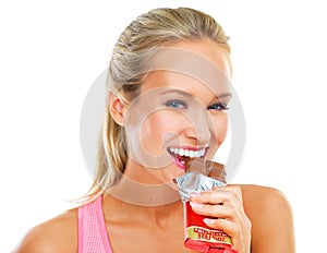 White background, portrait and bite of chocolate by woman, smile and cheat day on diet for athlete. Adult, female person
