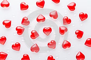 white background with red hearts pattern and water drops, flat lay