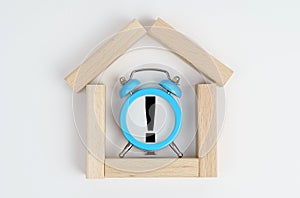 On a white background, a small house made of wooden boards, inside an alarm clock with an exclamation mark