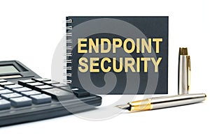 On a white background, there is a calculator, a pen and a black notebook with the inscription - ENDPOINT SECURITY