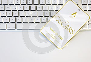 White badge with the Academy Awards Oscars logo and the date of the event on a computer keyboard