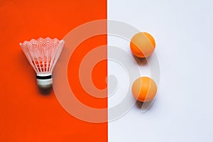 White badminton shuttlecock and orange ball for table tennis on an orange-white background.