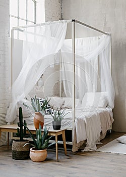 White baldachin over bed in boho chic style bedroom