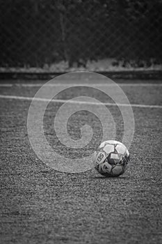 White ball on the grass of an empty soccer field