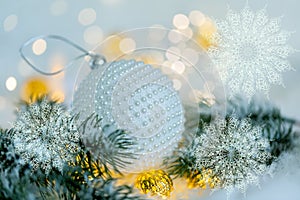 Christmas and New Year Holiday greeting card. Beautiful ball, pine branches and a garland in the snow. Snowflakes
